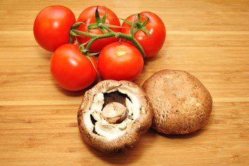 Five Fresh Tomatoes with Mushrooms Over a Wooden Background