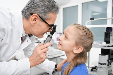 Fototapeta premium View from side of oculist checking sight of girl in clinic