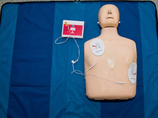 Automated external defibrillator with training dummy mannequin.