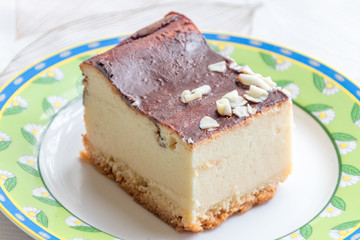 Slice of cheesecake with chocolate on the top.