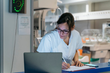 Hospital staff working on some paper and computer