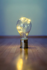 Ideas and innovation: Light bulb with LEDs is lying on the wooden floor. Copy space.