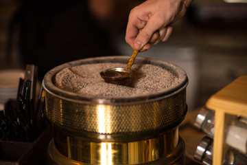 Cooking Turkish coffee in sand and a cezve. Turkish coffeee is a traditional hot drink in Turkey.