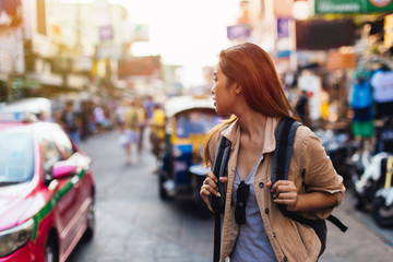Fototapeta premium Young Asian female tourist woman walking and backpacking on Khaosan road in Bangkok, Thailand. Travel and Backpack in Asia concept