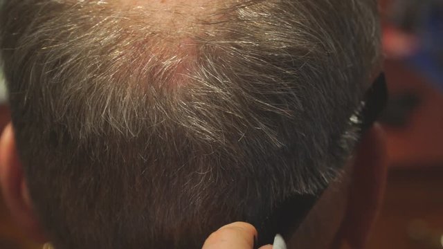 Woman Hairdresser cuts man's hair with electric clipper trimmer. Selective focus