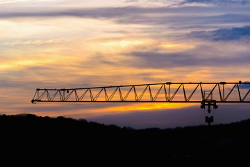 Crane girder silhouette industrial at sunset over heels