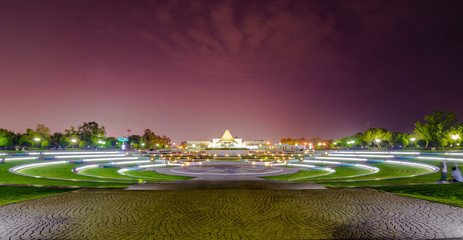 Panorama shot of park center area filled with grass in circles and play area with twilight sky...