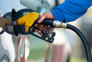 Man filling gasoline fuel in car holding nozzle