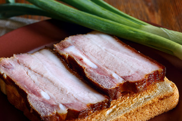 Slices of bacon on white bread toast