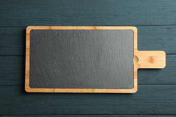Cutting board on wooden background, space for text