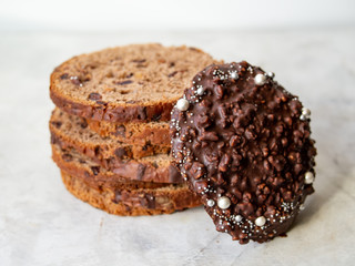 Amazing Chocolate Easter Cake with chocolate drops and dry cherries on gray wooden background. Round slices of cake. Easter concept. Selective focus, close up