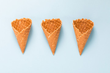 Three Waffle cornet on light blue background.