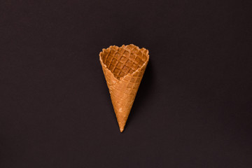 Sweet wafer cone isolated on brown background.