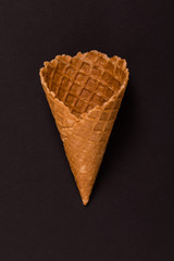 Sweet wafer cone isolated on brown background.