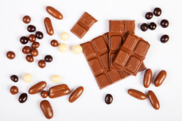 Milk chocolate pieces isolated on white background from top view