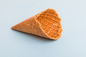 Waffle cornet isolated on light blue background.