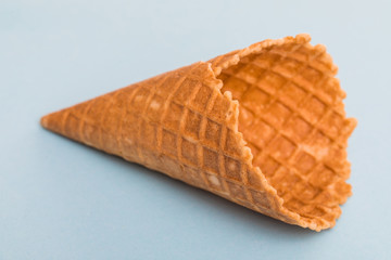 Waffle cornet isolated on light blue background.