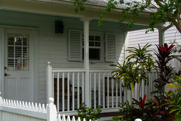 Fototapeta premium Relaxing front porch on a white house in a tropical setting in the shade