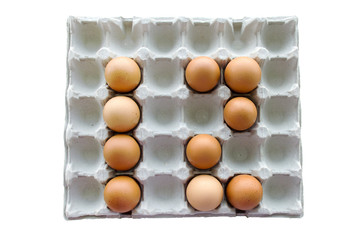 An isolated close-up of brown chicken eggs lay in a cardboard tray in the form of the number 12. Easter Concept