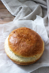 Fresh homemade wheat yeast bread on a linen tablecloth. Rustic style.