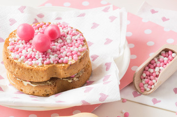 rusk with white and pink aniseed balls, Dutch Muisjes, traditional food in The Netherlands when a baby girl is born