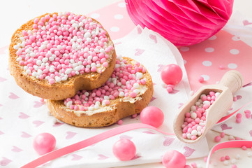 rusk with white and pink aniseed sprinkles, Dutch Muisjes, traditional food in The Netherlands when a baby girl is born