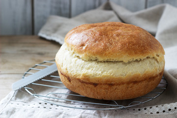 Fresh homemade wheat yeast bread on a linen tablecloth. Rustic style.