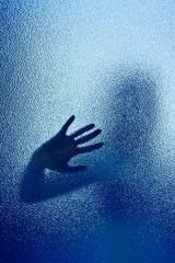 silhouette of a woman through frosted translucent glass, enigmatic gloomy silhouette