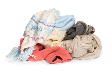 Stack of various sweaters on white background.