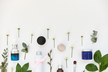 Cosmetics background with green branches and flowers, advertising poster for your store and stock, top view, copy space for text