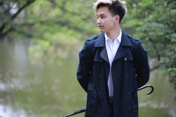 Spring rainy weather and a young man with an umbrella