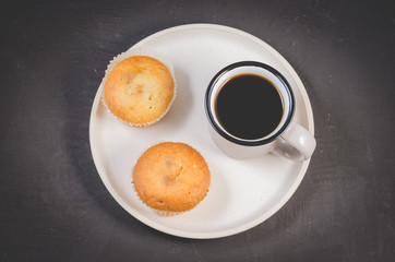 coffee break. Cup of the black coffee and cupcakes on a white tray, top view. Breakfast concept