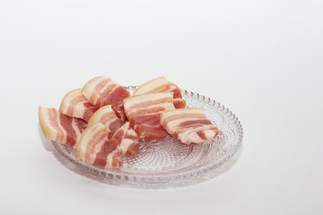 Chopped small pieces of pork belly on glass plate. Juicy pieces of bacon.
