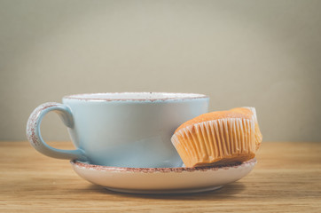 muffins and blue mug with tea for breakfast, selective focus