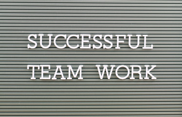 Successful team work written with white plastic letters on grey board