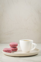 sweet macaroons or macaron in a white bowl and coffee cup on a white background, french dessert