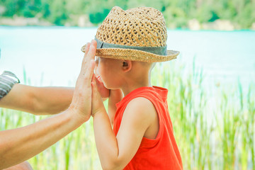 hands of a parent and child in nature in a park by the sea