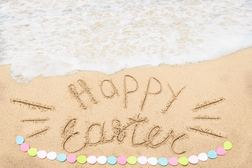 Happy easter lettering background with eggs on the sandy beach