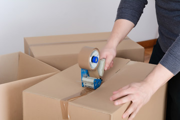 Man sealing a shipping cardboard box