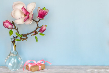 still life with beautiful spring magnolia flowers and gift box. holiday or wedding background