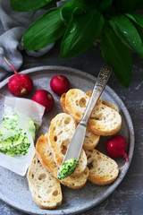 Butter with wild garlic, slices of bread and radish, ingredients for making a sandwich.