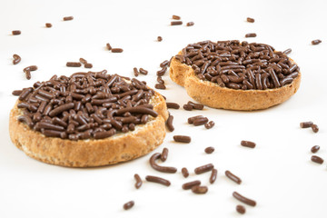 Traditional breakfast in The Netherlands: rusk with chocolate sprinkles, Dutch Hagelslag, against white background