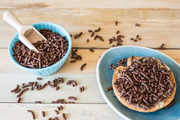 traditional Dutch food, chocolate hail, hagelslag, on rusk against wooden background