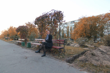 Obraz premium young woman reading a book on the bench in the park. Pretty young student reading a book outside on the campus. The girl reading the book on the bench. hobbies, literature, poets, book, park