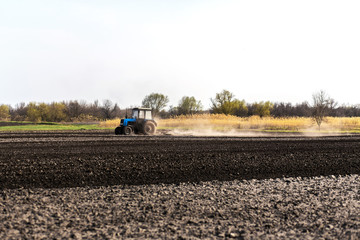 a tractor plows a field for sowing crops
