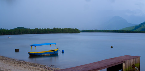 Wide view on blue fishing boat at landing state in the jungle 