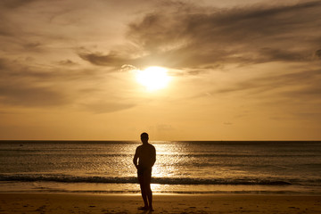 Fototapeta na wymiar Man watching sunset on the beach