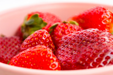 Ripe red strawberry closeup lies in a cup.