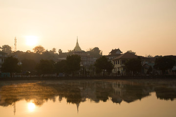 Fototapeta na wymiar Kengtung at dawn. Beautiful sunrise and the reflection of building around the Tung lake. 