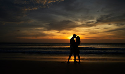 Fototapeta na wymiar Happy couple on the beach at sunset kissing. Thailand, Phuket Island
